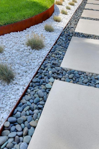 Concrete slab walkway with river rock and white gravel infill between the panels.
